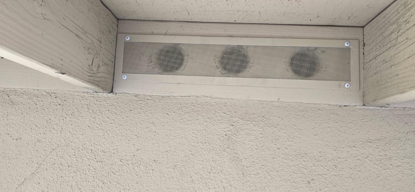 After: ember-resistant eave vent screen installed with 1/8-inch corrosion-resistant mesh, painted to match