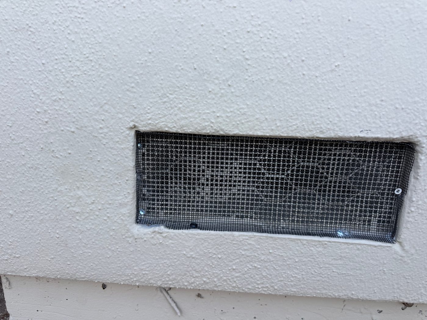 After: foundation vent retrofitted with 1/8-inch ember-resistant mesh