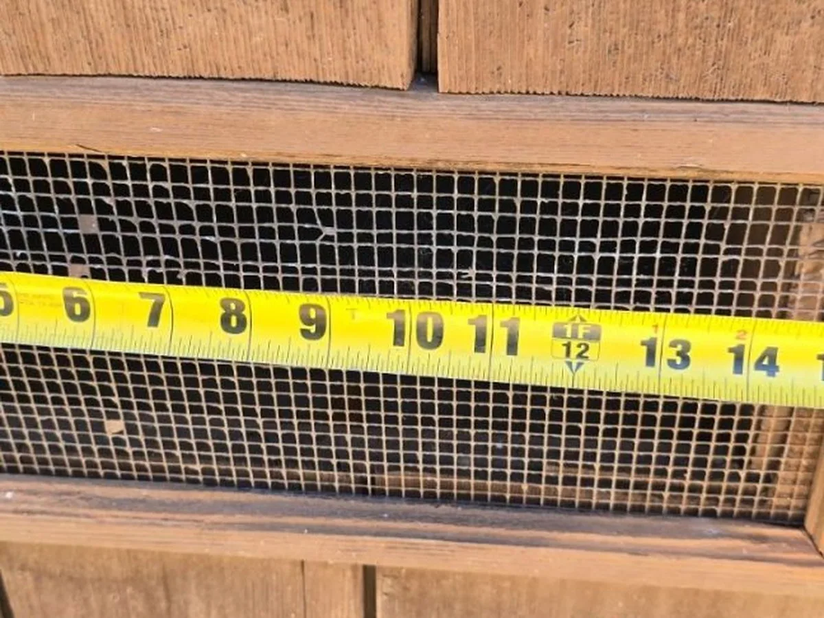 Before: the existing quarter-inch galvanized screen at a gable vent. The openings sit well above ember size.