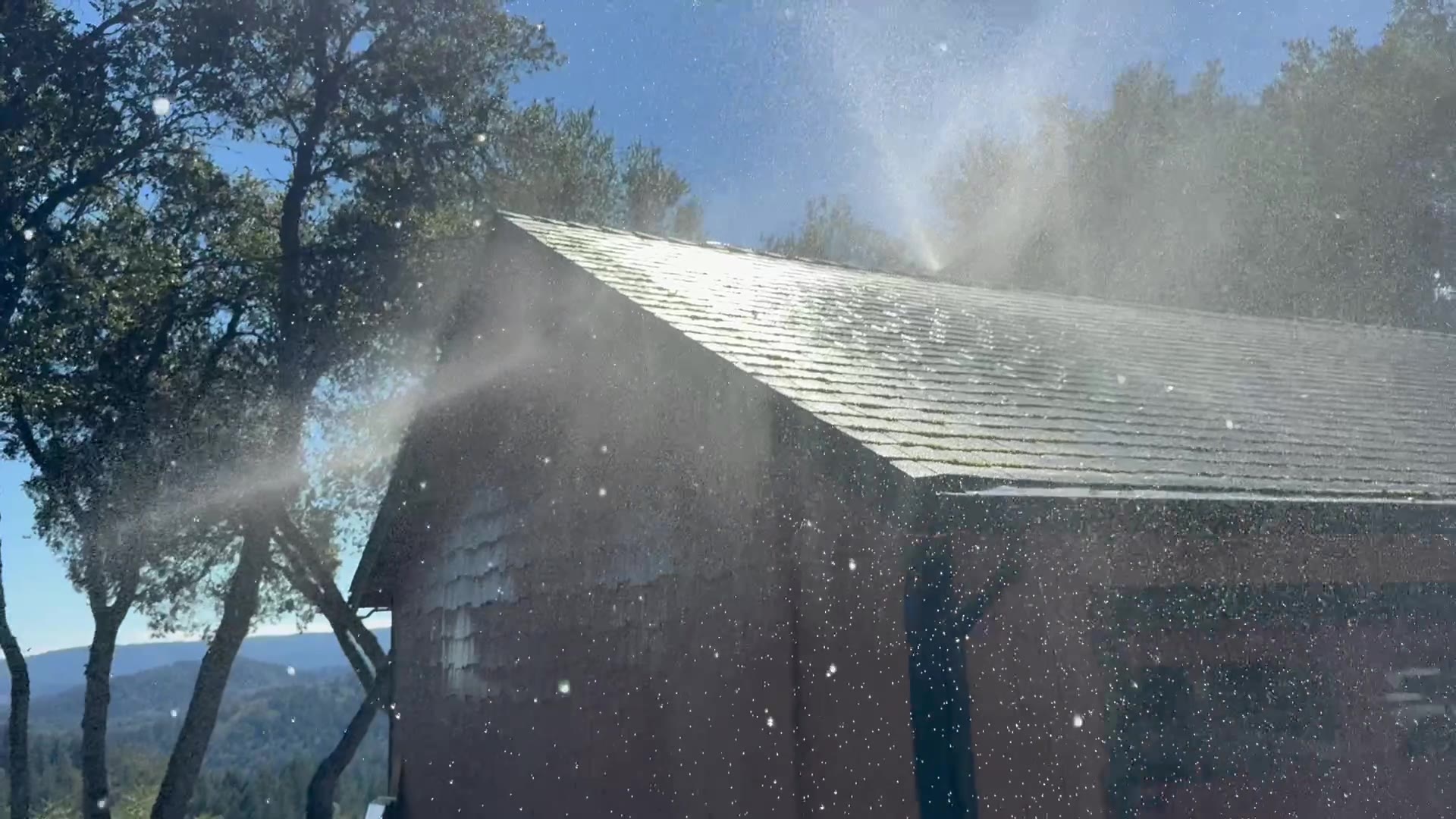 Roof and eave sprinklers running a live coverage test on a detached garage. The main house is protected by the same system.